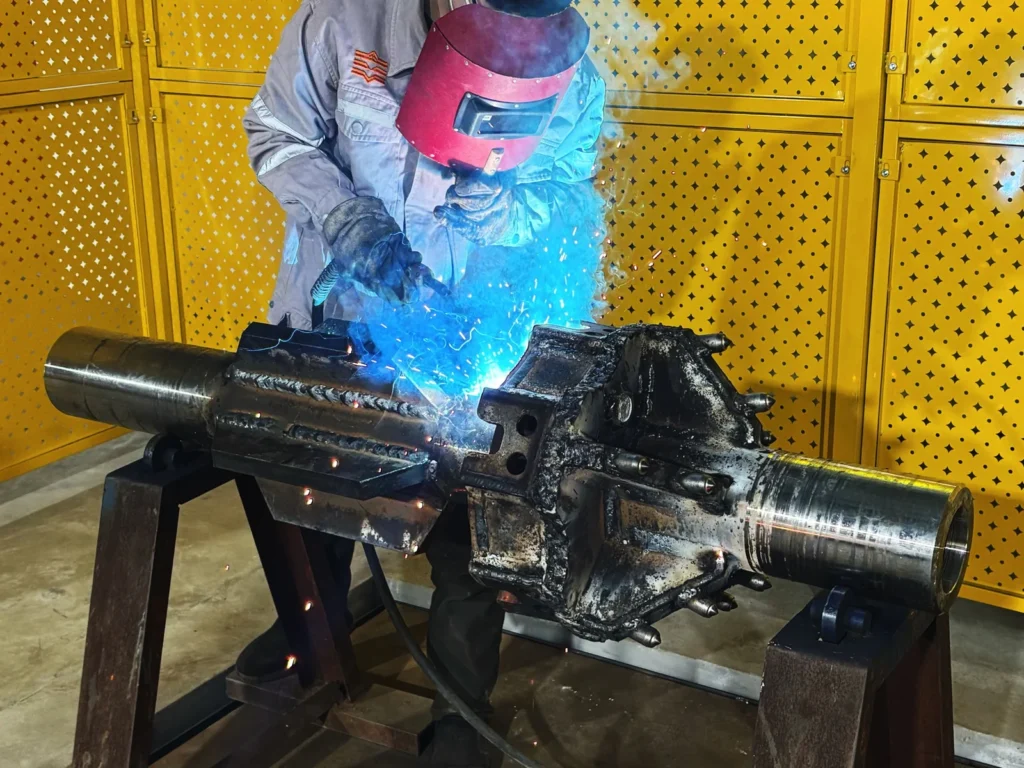 DRILLNOVA welder fabricating a bolt-on hole opener during the manufacturing process