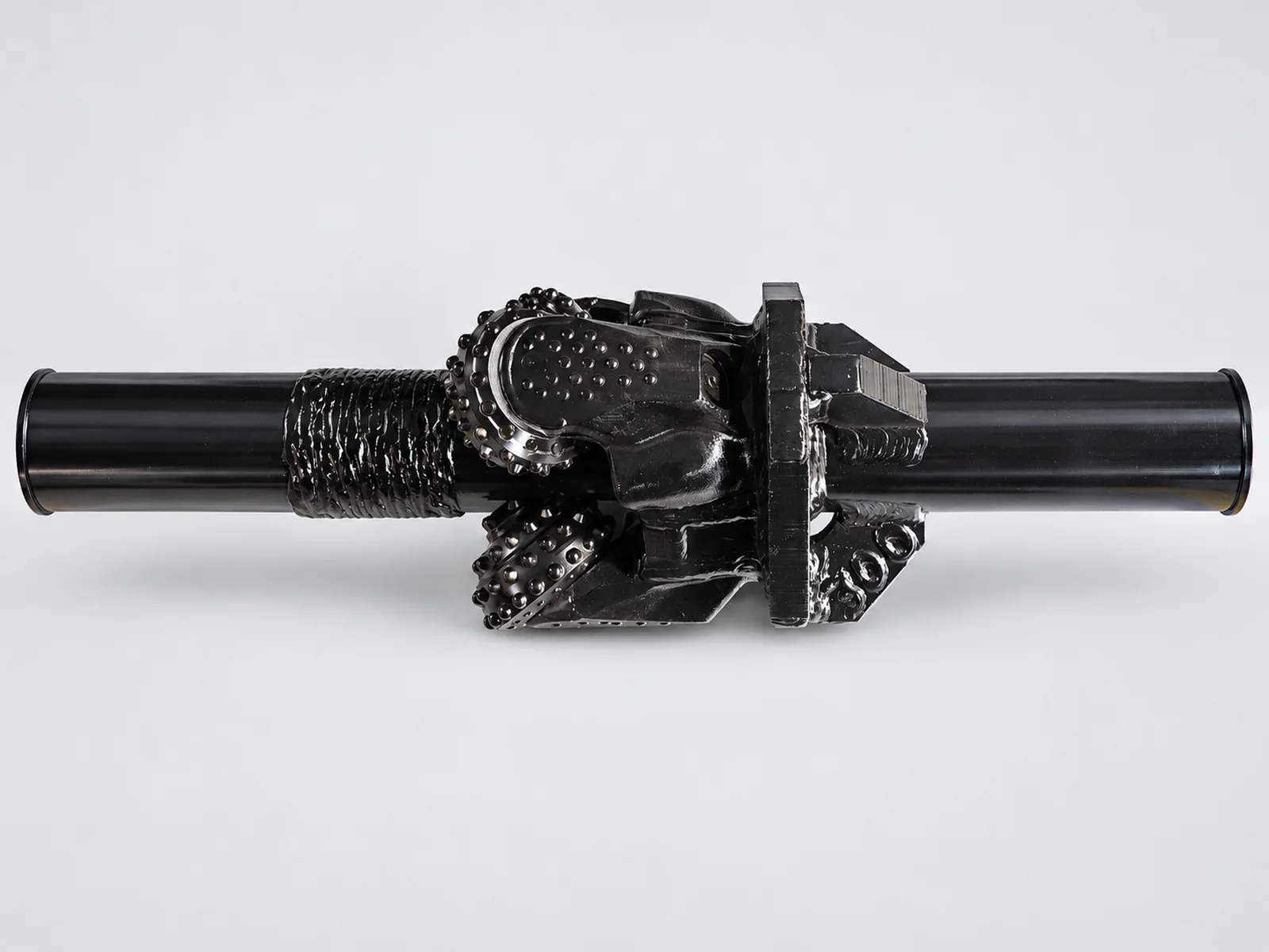 Single black Fixed Type Hole Opener with roller-cone cutters and long cylindrical shafts.